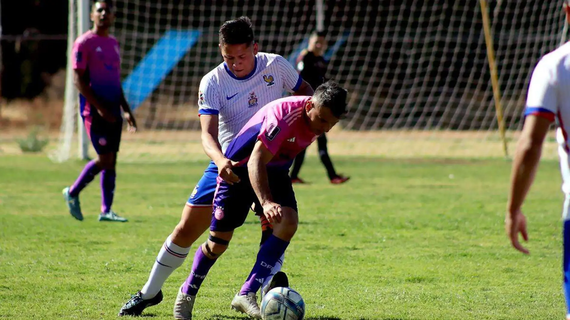 Dos jugadores se disputan el balón durante un partido